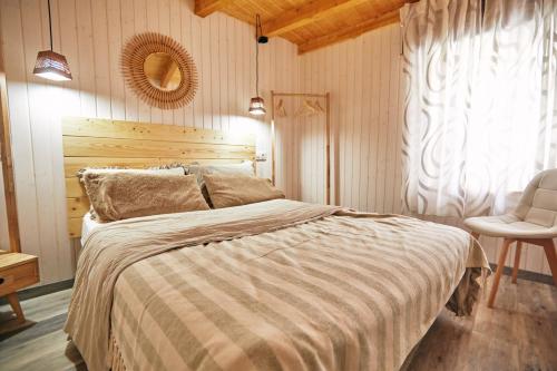 1 dormitorio con 1 cama grande y 1 silla en Casa Montse. Apartamentos turísticos, en Ribadeo