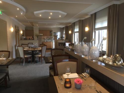 a restaurant with tables and chairs and a dining room at Landhotel Alberts in Heijenrath