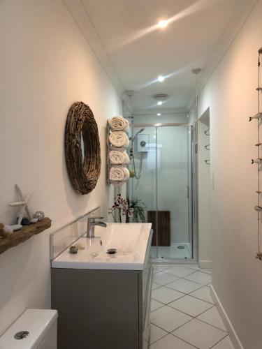 a bathroom with a sink and a toilet and a shower at Ocean Drive Boutique Apartment complimentary Tray in Brean