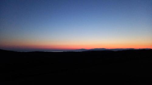 un coucher de soleil dans le ciel et des montagnes en arrière-plan dans l'établissement Sea Crest Pods, à Rossnowlagh