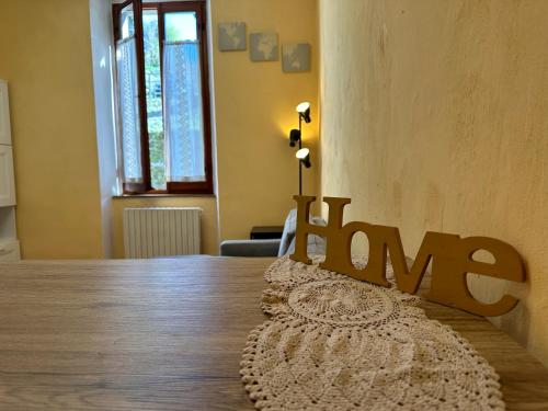a wooden table with a sign that says home at Dimitri's House! view of the Cathedral in Castelnuovo di Garfagnana