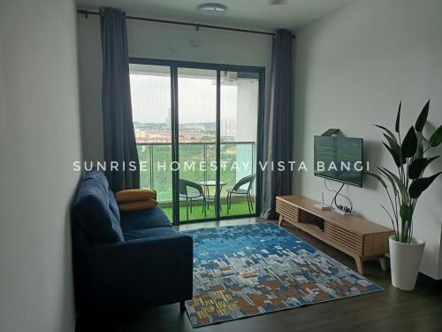 een woonkamer met een bank en een groot raam bij Sunrise Homestay Vista Bangi in Kajang