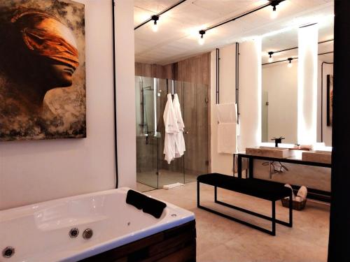 a bathroom with a large bath tub and a sink at Hotel Tila in Cholula