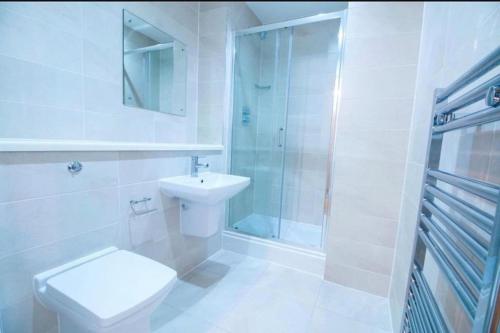 a bathroom with a toilet and a shower and a sink at Luxury Apartment near Media City in Manchester