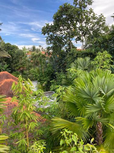 a garden with lush green plants and a river at The CIVYT in Ubud