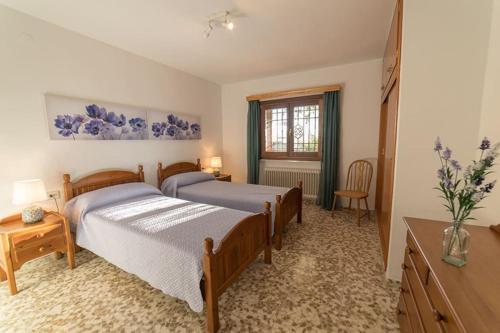 1 dormitorio con 2 camas y ventana en Casa Surya - unique country house near Granada, en Nigüelas