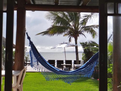 a hammock on a patio with a view of the ocean at Pousada Pedra da Gaivota in Bombinhas