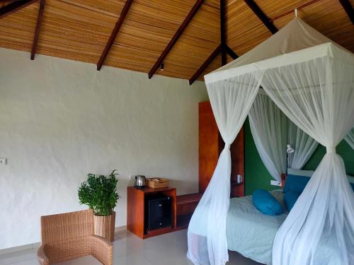 um quarto com uma cama com rede mosquiteira em Ilasan cottage. em Tomohon
