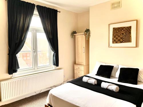 een slaapkamer met 2 bedden en een raam bij Aldgate Holiday Rooms in Londen