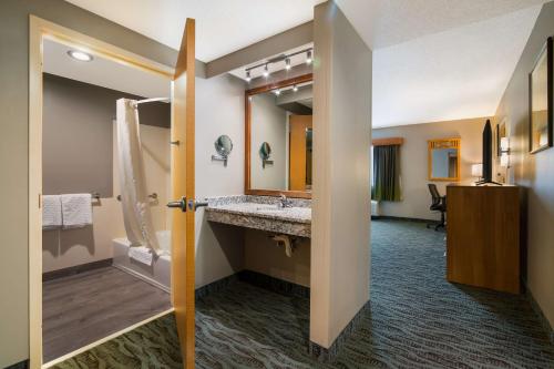 a bathroom with a sink and a large mirror at Best Western PLUS Executive Court Inn & Conference Center in Manchester