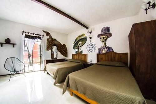 a bedroom with two beds and a top hat at Gente de Más Hostel in Puebla