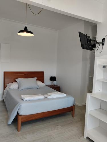 a bedroom with a bed with a tv on the wall at Hotel Miranda do Douro in Miranda do Douro
