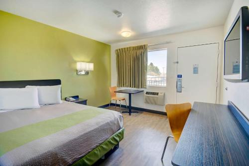 Habitación de hotel con cama, escritorio y ventana en Motel 6-Douglas, AZ, en Douglas
