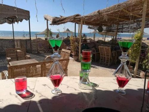 cuatro copas de vino sentadas en una mesa cerca de la playa en Blue Lagoon Village Ras Sidr (قرية بلولاجون راس سدر) (عائلات فقط), en Ras Sedr