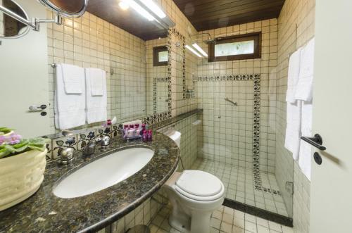 a bathroom with a sink and a toilet at Oasis Hotel Spa in Gravatá