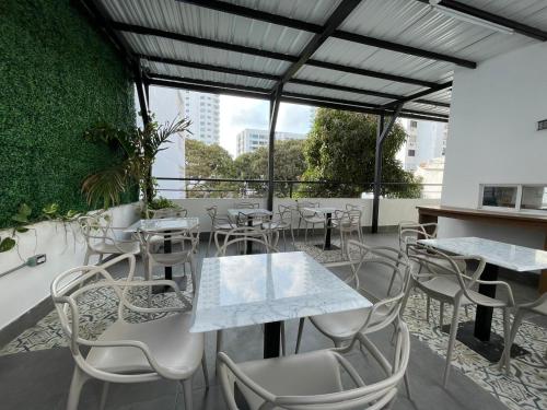 a restaurant with tables and chairs on a balcony at Hotel Amoek in Cartagena de Indias