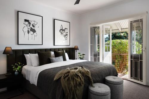 a bedroom with a large bed with two pictures on the wall at Sunshine House in Daylesford