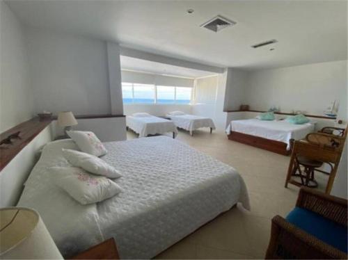 a large bedroom with two beds and a balcony at Marie Joseph Villa in San Andrés