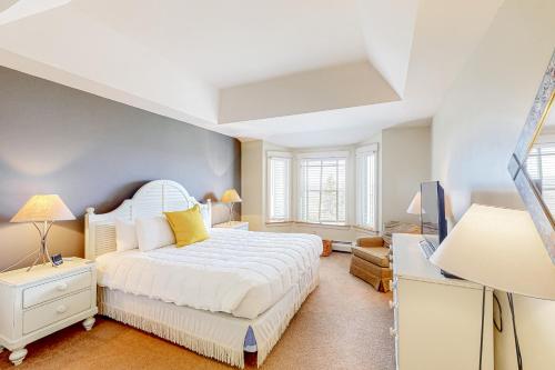 ein Schlafzimmer mit einem weißen Bett und einer blauen Wand in der Unterkunft Chateau Sunrise - Solitude Village K203 in Ludlow
