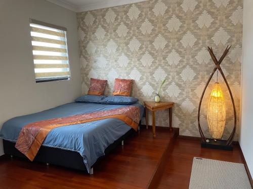 1 dormitorio con cama con sábanas azules y ventana en Comfortable Luxury Home, en Perth