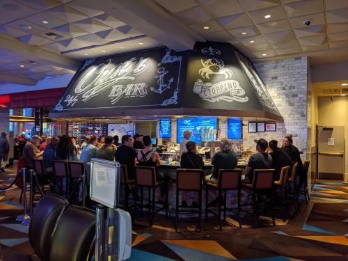 a group of people sitting at a bar in a restaurant at Beautiful Unit in Harrah's Casino Strip LAS VEGAS in Las Vegas