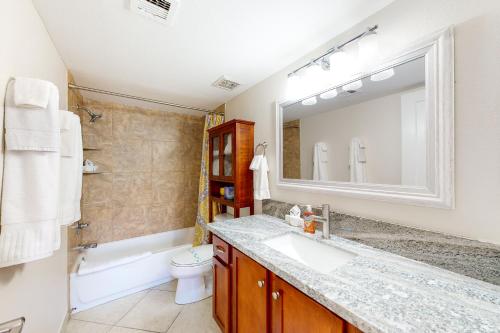 La salle de bains est pourvue d'un lavabo, de toilettes et d'un miroir. dans l'établissement Boardwalk Condos, Unit 1034, à Chandler