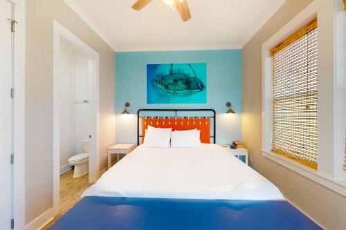 een slaapkamer met een groot bed met blauwe muren bij East Side Cottages #C- Shipwreck Cottage in Gulf Shores