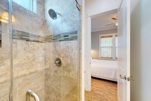een badkamer met een douche en een glazen deur bij East Side Cottages #C- Shipwreck Cottage in Gulf Shores