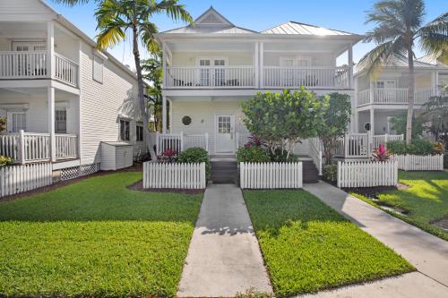 a large white house with palm trees and grass at Palm Villa in Duck Key