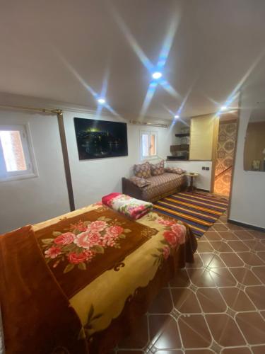 a bedroom with a bed and a couch in a room at Maison traditionnelle de lahbib in Rabat