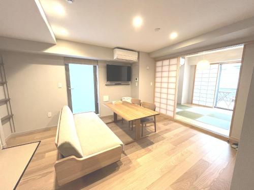 a room with a table and a couch and a dining room at KLASSO Tokyo Sumiyoshi Apartments in Tokyo