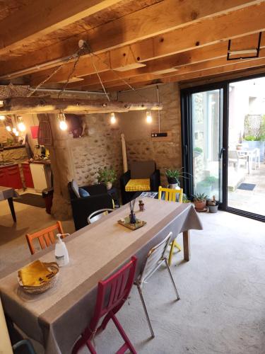 a living room with a large table and chairs at Les Figuets in Châteauneuf-de-Galaure