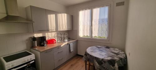une petite cuisine avec une table et une fenêtre dans l'établissement Chez Toni, à Troyes