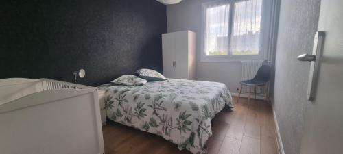 niewielka sypialnia z łóżkiem i oknem w obiekcie Chez Toni w Troyes