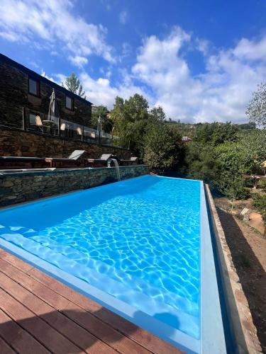 a blue swimming pool on a wooden deck at Moinhos do Paiva in Castelo de Paiva