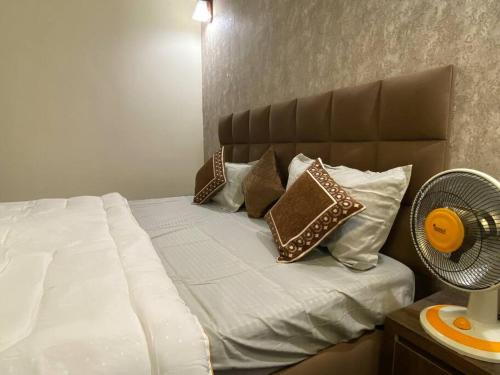 a bedroom with a bed with pillows and a fan at Tara Luxury Homes in Solan