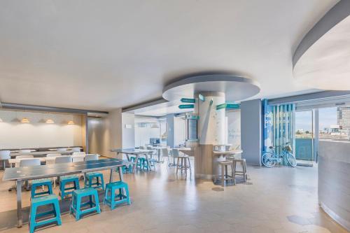 a restaurant with blue stools and tables and chairs at One Puebla Angelopolis Periferico in Puebla