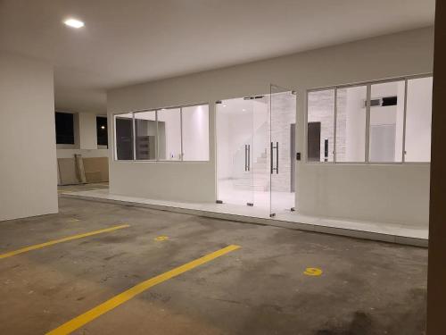 un aparcamiento vacío con puertas de cristal en un edificio en Suite Chipipe AC Wi-Fi Lavanderia a 1 cuadra mar en Salinas