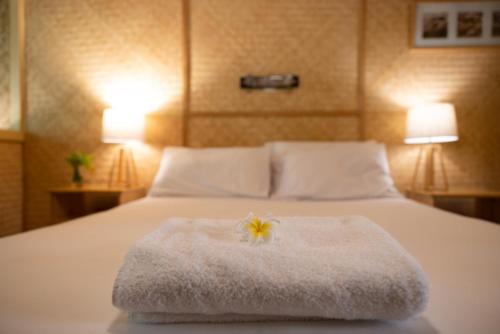 białe łóżko z kwiatem na górze w obiekcie Tallow Beach Motel w mieście Byron Bay