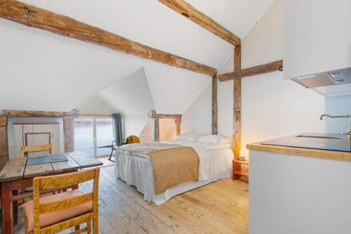 a bedroom with a bed and a sink in a room at Sveggvika Guesthouse in Averoy