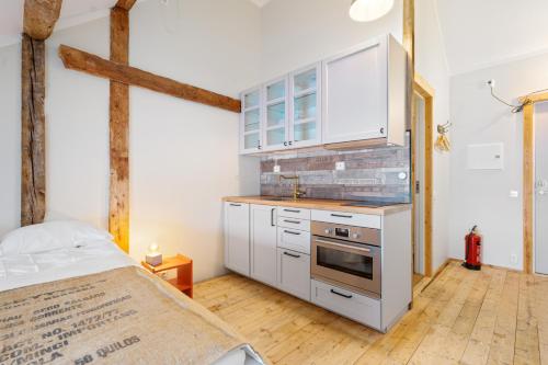 a kitchen with white cabinets and a stove at Sveggvika Guesthouse in Averoy