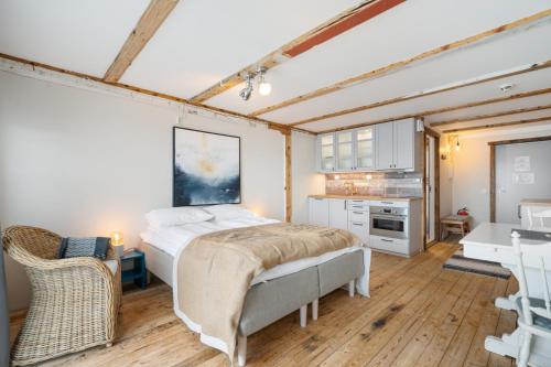 a bedroom with a large bed and a kitchen at Sveggvika Guesthouse in Averoy