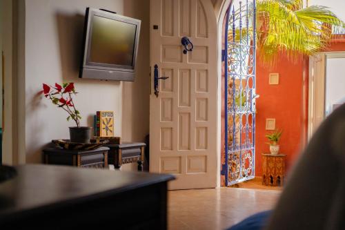 a living room with a door and a tv at Little Kasbah in Imsouane