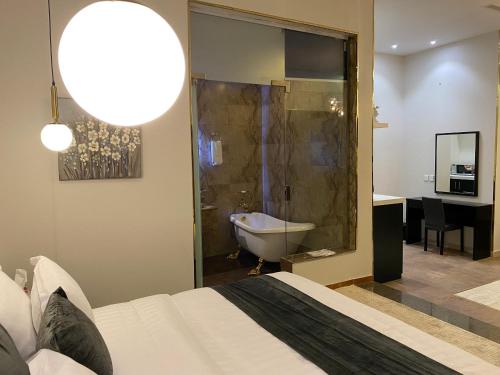 ein Schlafzimmer mit einem Bett und ein Badezimmer mit einer Badewanne in der Unterkunft New Day Resort منتجع يوم جديد in Ta'if