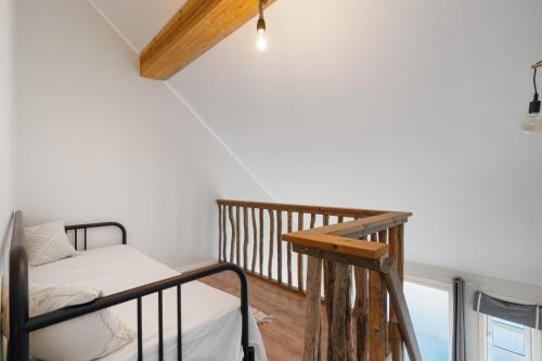 a small bedroom with a bunk bed and a balcony at Sveggvika Guesthouse in Averoy