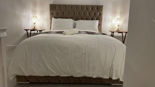 1 dormitorio con 1 cama grande y 2 mesitas de noche en Deluxe En suite Bedroom with free on site parking en Milton Keynes