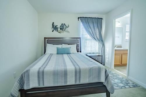a bedroom with a bed with a blue and white comforter at 5 Bd Villa Home Theater Private Pool Game Room in Davenport