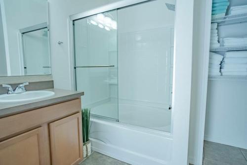a bathroom with a glass shower and a sink at 5 Bd Villa Home Theater Private Pool Game Room in Davenport