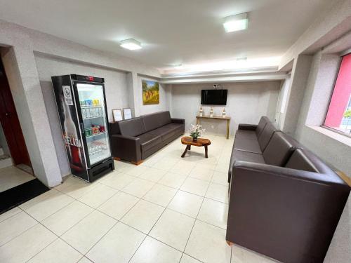 una sala de espera con sofás y una máquina de refrescos en Hotel Savana, en Olímpia