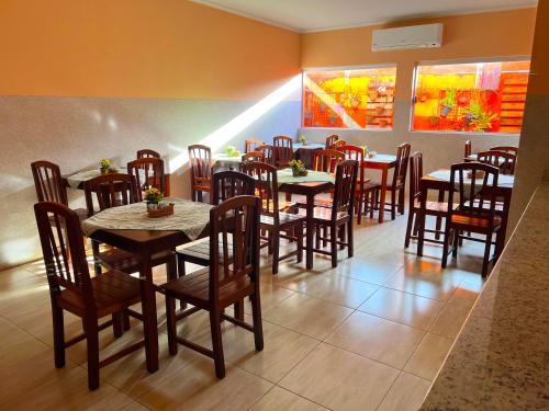 a dining room with tables and chairs in a restaurant at Hotel Savana in Olímpia